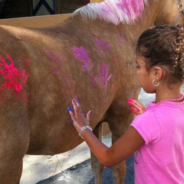 Kid hand painting with horse