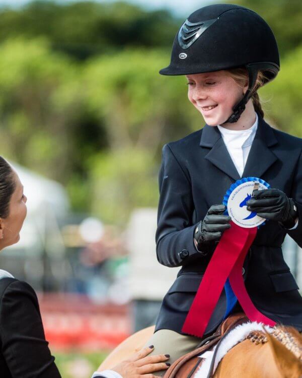 Girl with award ribbon in hand